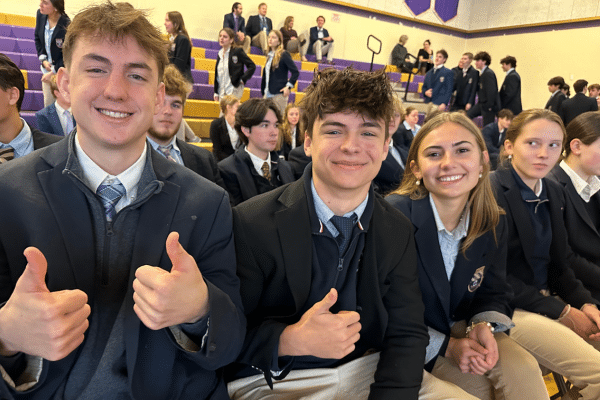 students giving thumbs up on bleachers in school gym