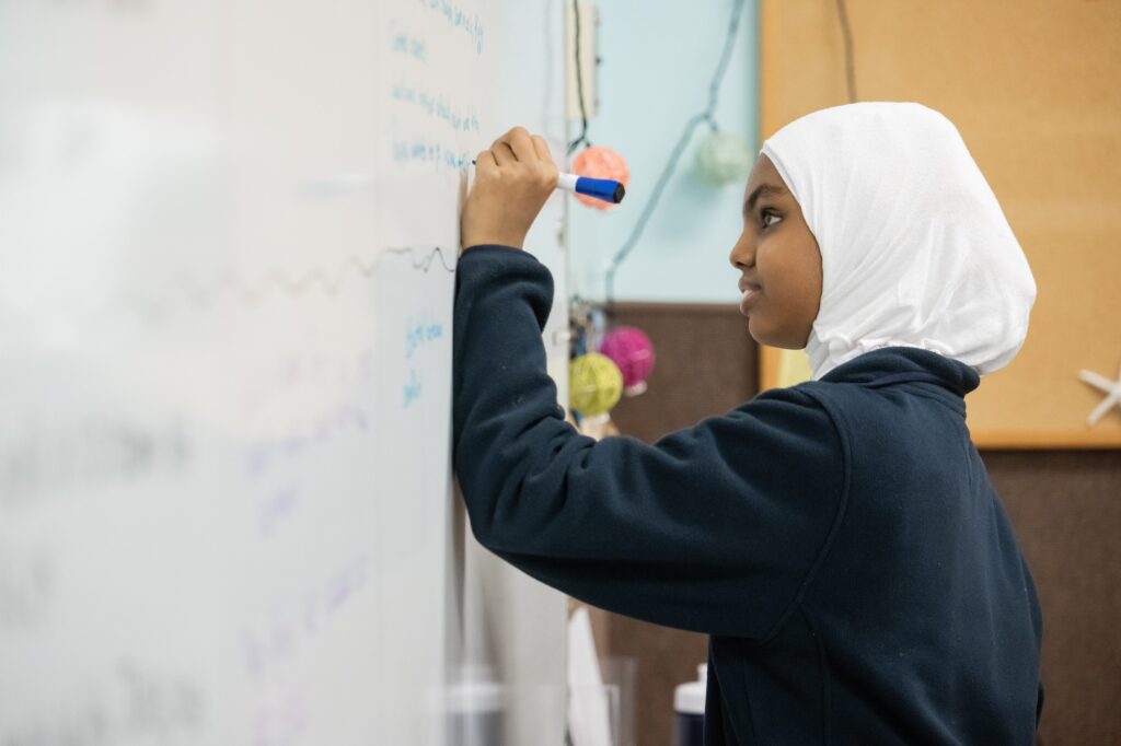 girl writing on whiteboard