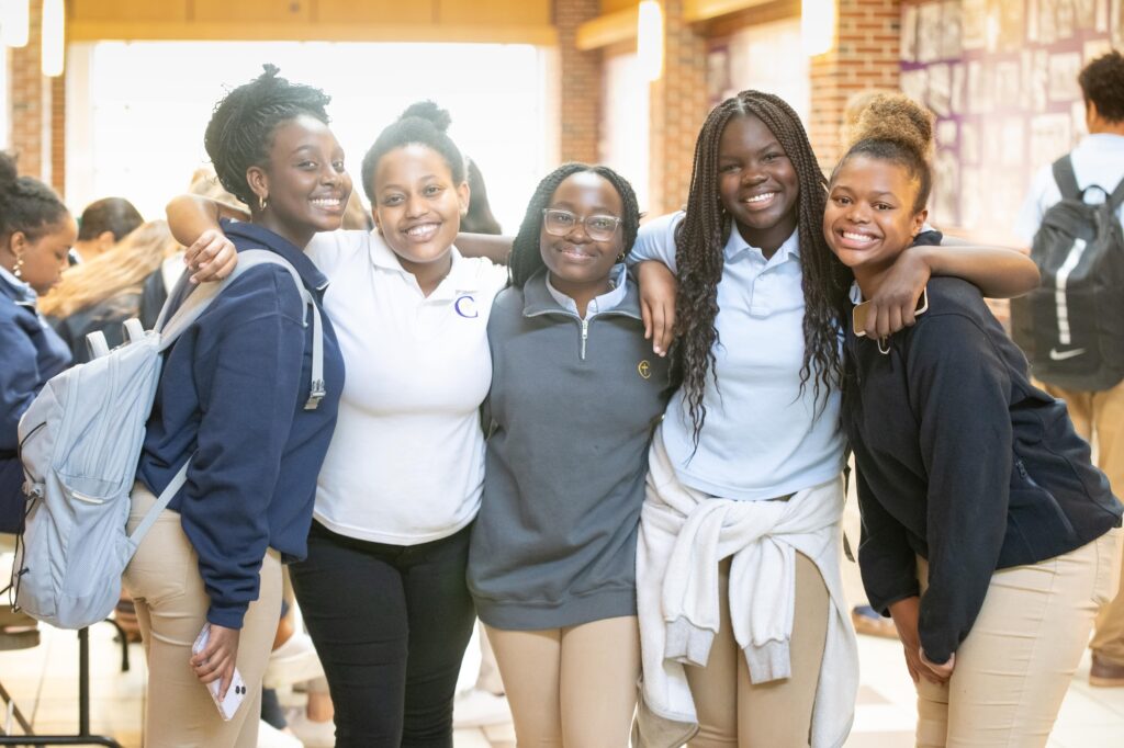 group of students posing for a photo in the hallway smiling