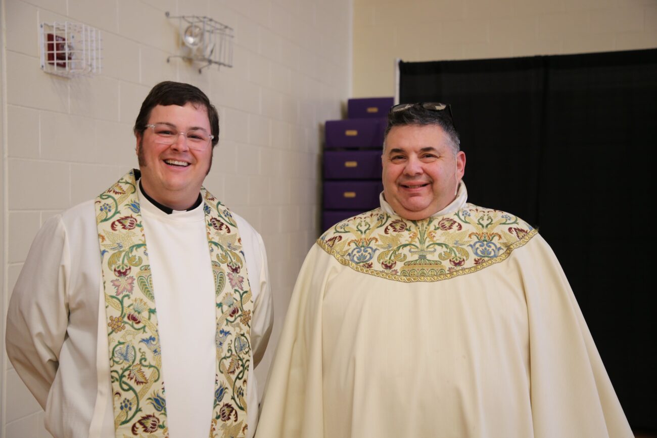 two priests smiling wearing robes